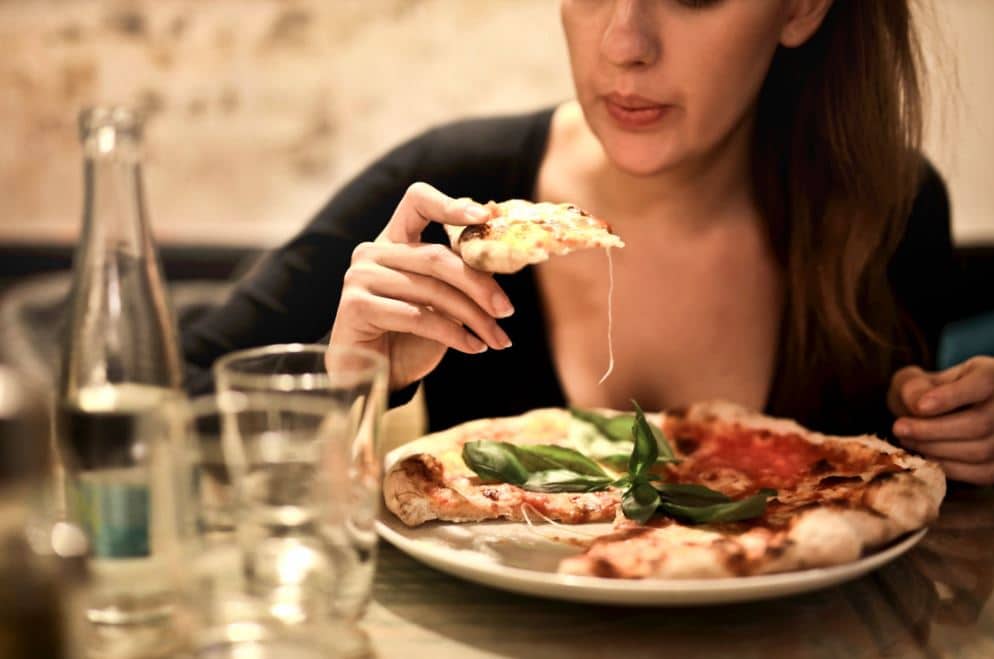 woman eating large plate of food past fullness