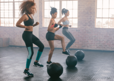 three women exercising with medicine balls at high intensity