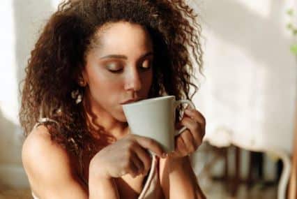 young woman sipping tea and looking peaceful