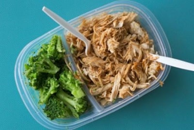 container with half shredded chicken and half broccoli to show extreme health choices