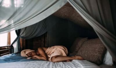 woman sleeping peacefully under a canopy to regulate her appetite