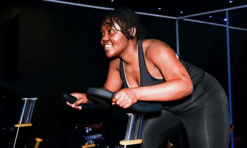 woman smiling while participating in spin class for intuitive movement
