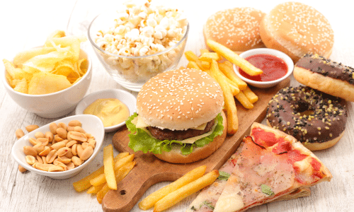 assortment of different junk foods like burgers and chips, which are often the target of sneak eating and eating in secret
