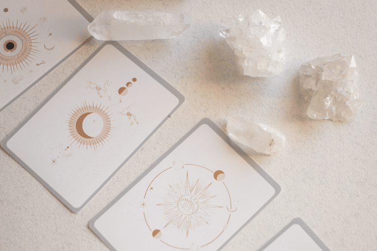 upside down tarot cards on white table with white crystals
